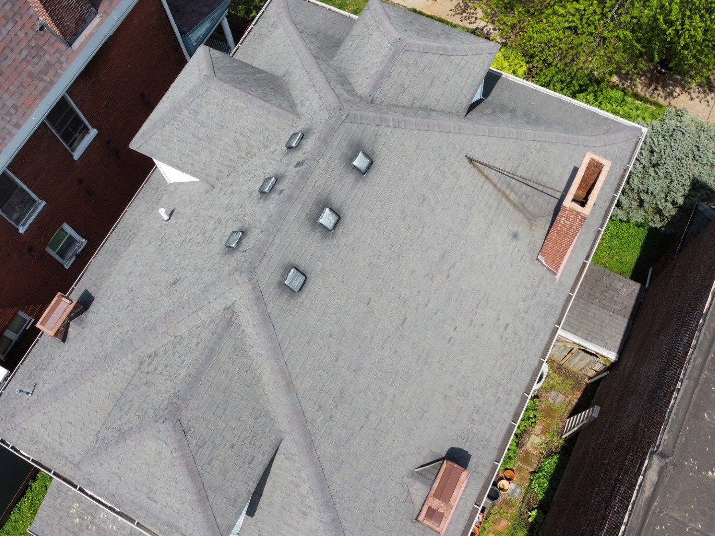 Overhead drone view of a large residential roof showing every slope, valley, chimney and skylight